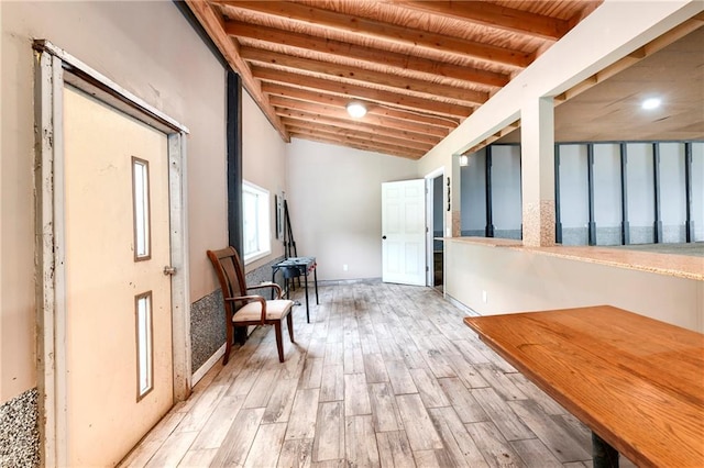 hallway with vaulted ceiling with beams and light hardwood / wood-style flooring