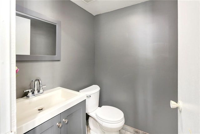 bathroom featuring vanity with extensive cabinet space and toilet