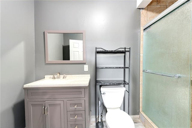 bathroom with walk in shower, vanity, and toilet