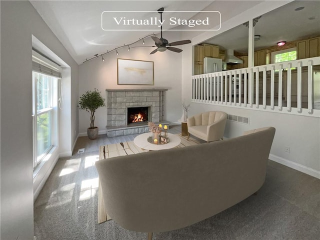 carpeted living room with ceiling fan and vaulted ceiling