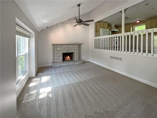 unfurnished living room with carpet floors, vaulted ceiling, and ceiling fan