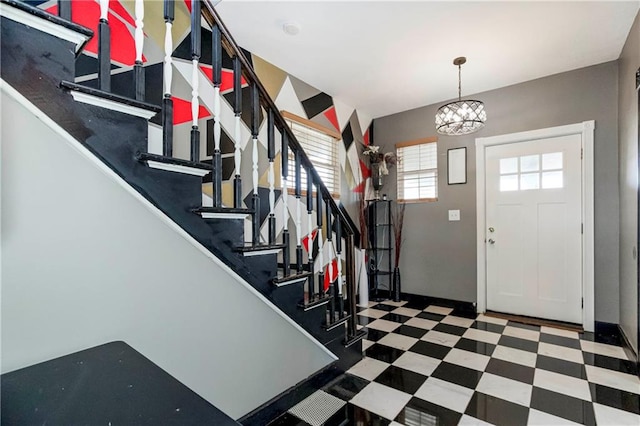 entrance foyer featuring dark tile floors and a chandelier