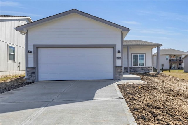 ranch-style house with stone siding, driveway, and a garage