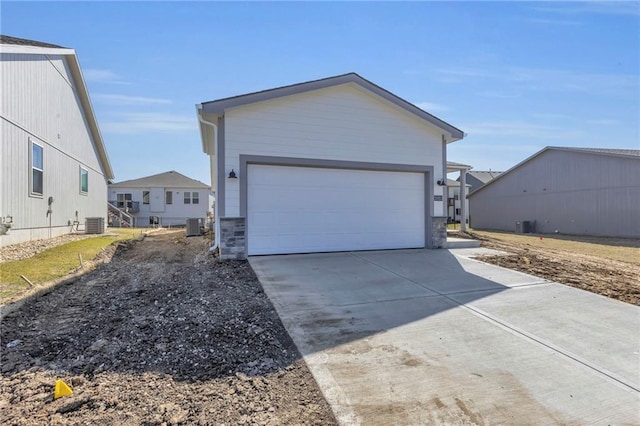 garage featuring concrete driveway and central air condition unit