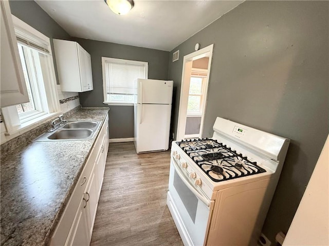 kitchen featuring white cabinetry, white appliances, sink, and light hardwood / wood-style floors