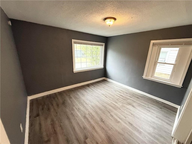 empty room featuring dark wood-type flooring and a textured ceiling