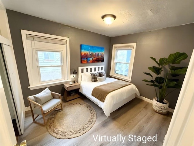 bedroom featuring hardwood / wood-style floors and a textured ceiling