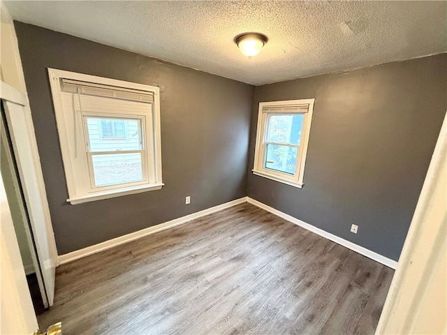 unfurnished room featuring a textured ceiling and hardwood / wood-style flooring