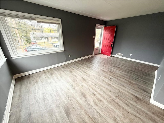 6133 Walrond Ave, Kansas City, MO 64130 - unfurnished room with wood finished floors, visible vents, and baseboards