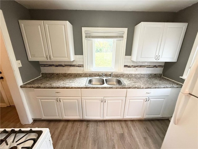 6133 Walrond Ave, Kansas City, MO 64130 - kitchen with a sink, backsplash, white cabinets, and light wood finished floors