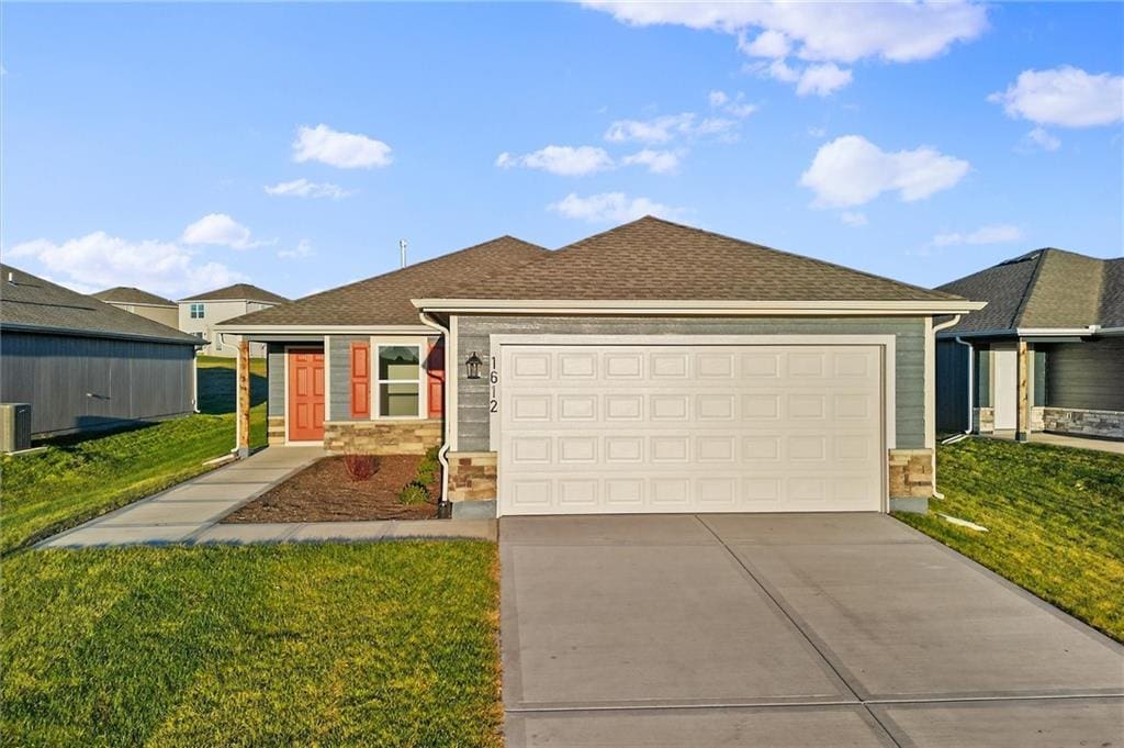 single story home featuring a garage and a front lawn