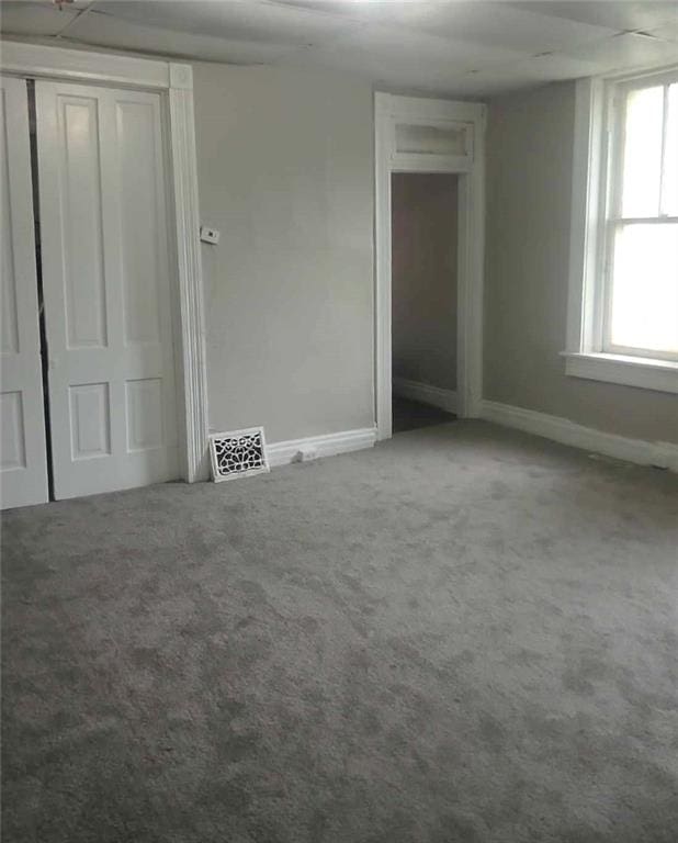 unfurnished bedroom featuring carpet floors and multiple windows