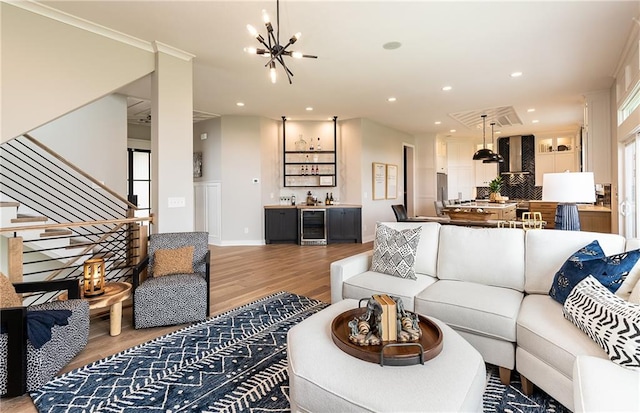 living room with wine cooler, a chandelier, and light wood-type flooring