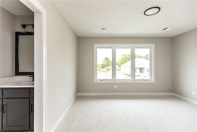 spare room with light carpet and sink