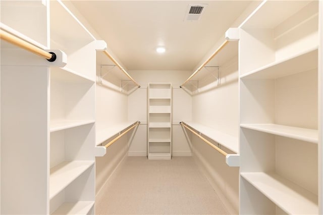 walk in closet featuring light colored carpet