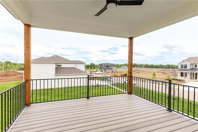 wooden deck featuring a lawn and ceiling fan