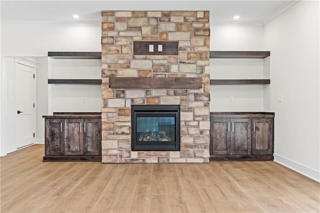 unfurnished living room with a fireplace, crown molding, and light wood-type flooring