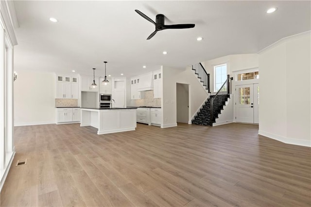 unfurnished living room with ceiling fan and light hardwood / wood-style floors