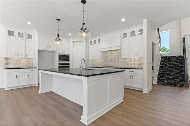 kitchen featuring premium range hood, stainless steel appliances, light wood-type flooring, and white cabinetry