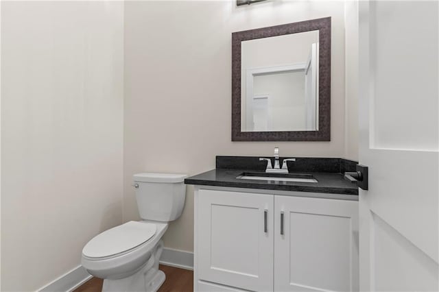 bathroom with hardwood / wood-style floors, vanity, and toilet