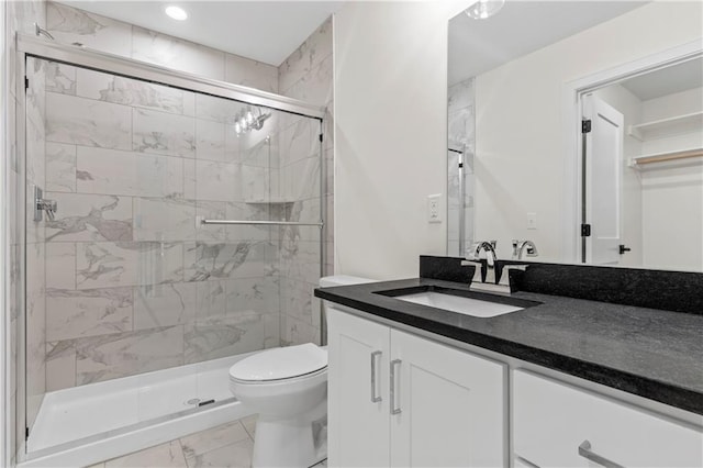 bathroom with a shower with shower door, toilet, tile floors, and vanity