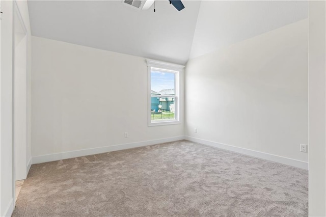 carpeted spare room featuring lofted ceiling and ceiling fan