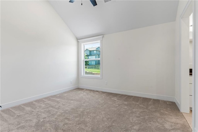 empty room with light colored carpet, vaulted ceiling, and ceiling fan