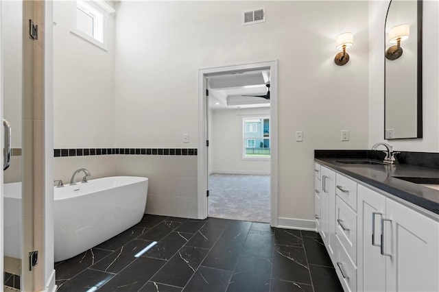 bathroom with a tub, tile floors, ceiling fan, and large vanity