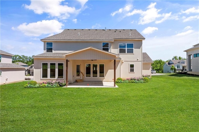 rear view of property with a patio and a lawn