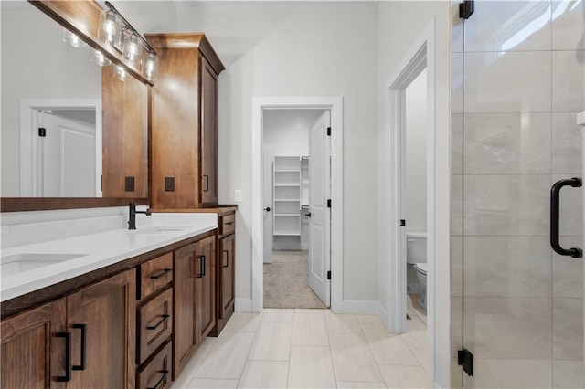 bathroom featuring vanity, a shower with shower door, toilet, and tile patterned flooring