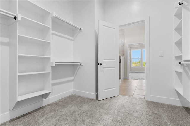 walk in closet featuring light carpet