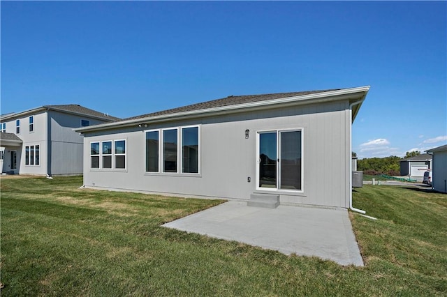 back of house featuring a patio area and a lawn