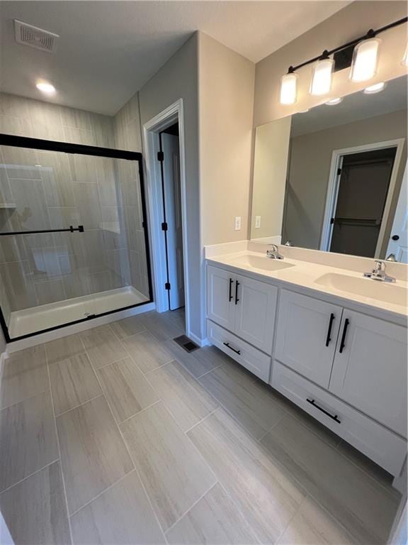 bathroom with vanity, tile patterned floors, and a shower with door