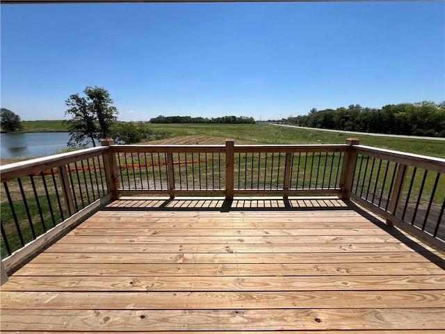 wooden deck with a yard and a water view