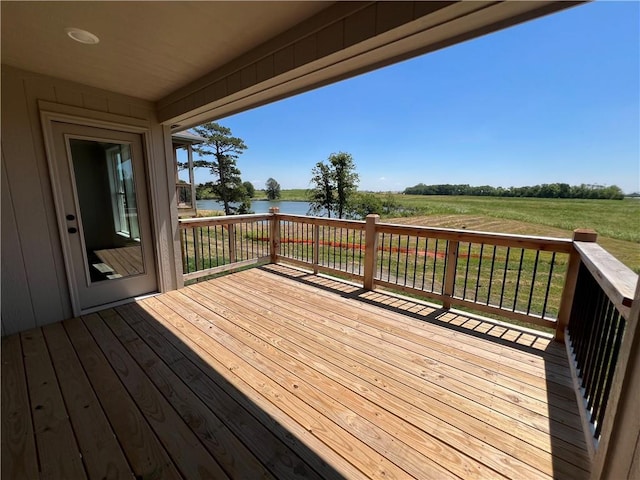 wooden deck featuring a yard, a rural view, and a water view