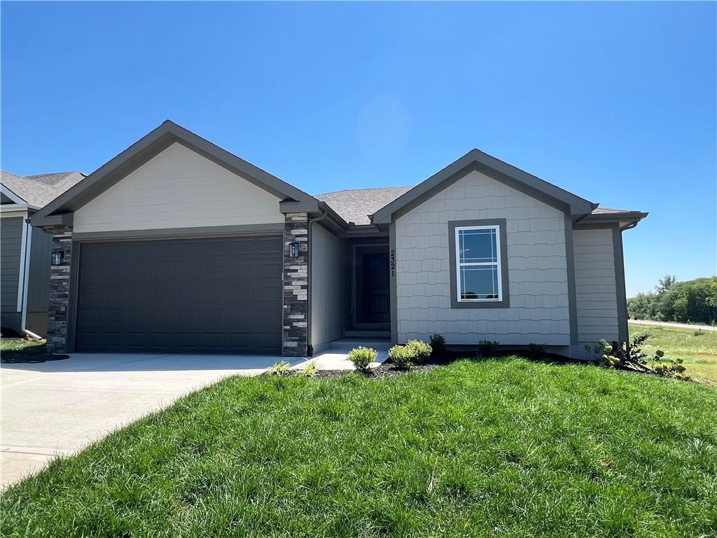 single story home with a front yard and a garage