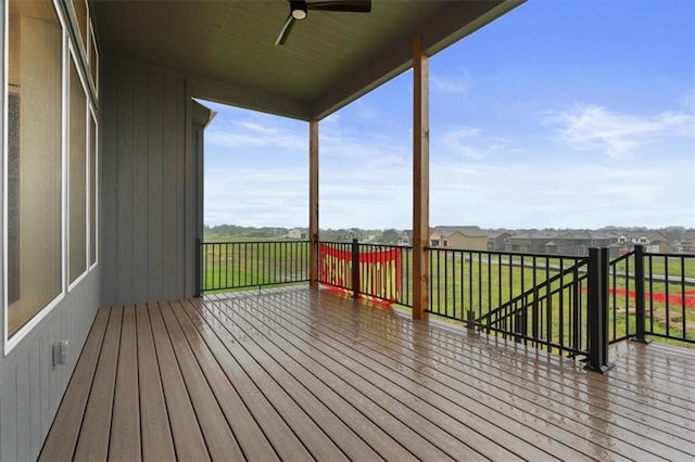 wooden deck with ceiling fan and a lawn