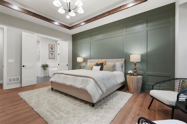 bedroom featuring light hardwood / wood-style flooring and an inviting chandelier