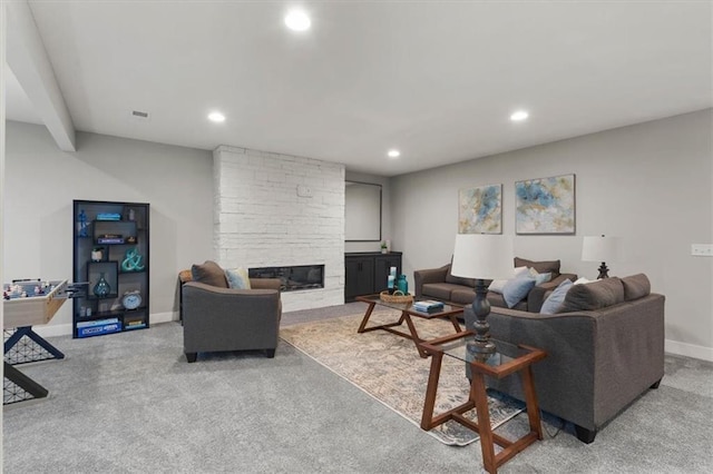 living room with light colored carpet and a stone fireplace