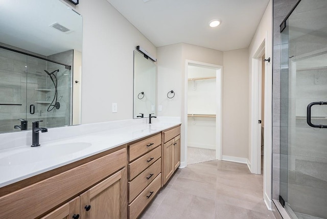 bathroom with tile patterned flooring, vanity, and walk in shower