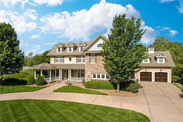 view of front of house featuring a porch, a garage, and a front lawn