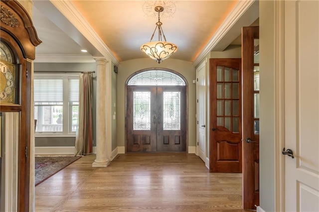 foyer with light wood-style floors, a wealth of natural light, lofted ceiling, and baseboards