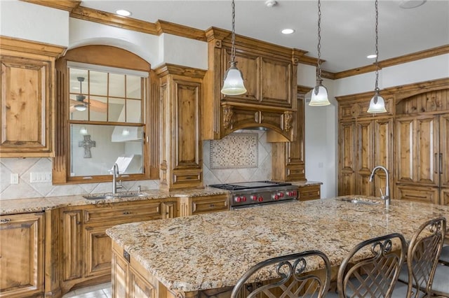 kitchen with high end stainless steel range oven, light stone counters, brown cabinets, and a sink