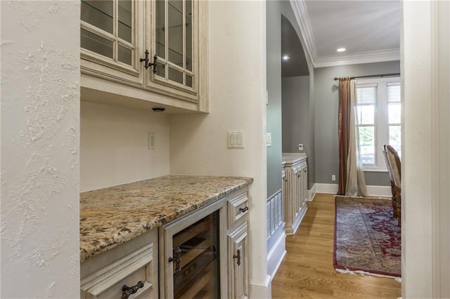 bar featuring recessed lighting, ornamental molding, light wood-style floors, beverage cooler, and baseboards