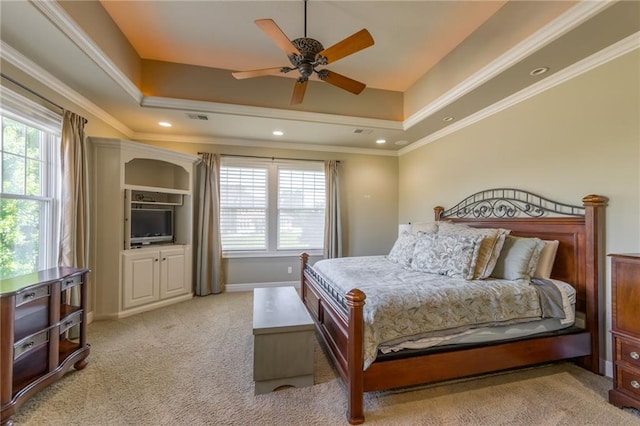 bedroom with light carpet, visible vents, a tray ceiling, and crown molding