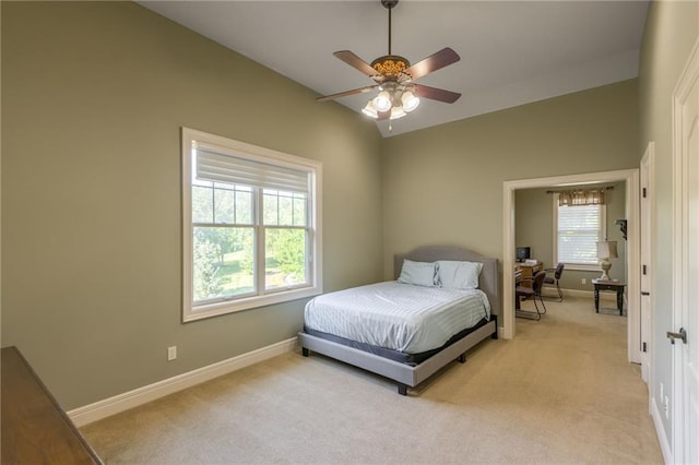 bedroom featuring light carpet, vaulted ceiling, baseboards, and ceiling fan