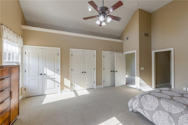 carpeted bedroom featuring baseboards, visible vents, ceiling fan, high vaulted ceiling, and two closets