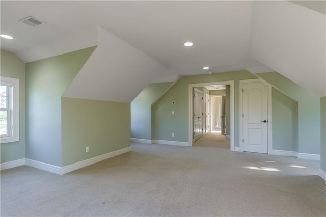 additional living space with recessed lighting, light colored carpet, visible vents, baseboards, and vaulted ceiling