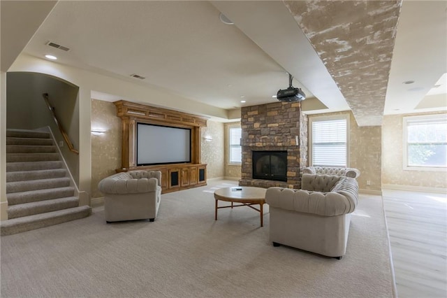 carpeted living area featuring baseboards, stairs, visible vents, and a fireplace