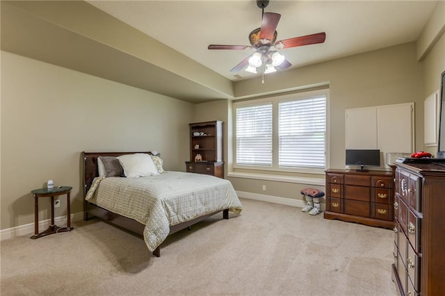 bedroom with light carpet, baseboards, and a ceiling fan